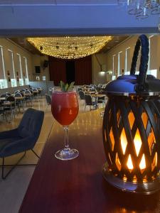 a drink in a glass on a table with a lantern at Cave apartment in Þórshöfn