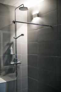 a shower with a glass door in a bathroom at Cave apartment in Þórshöfn