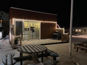 a house with lights on the side of it at night at Cave apartment in Þórshöfn +16 photos