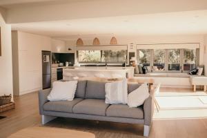a living room with a couch and a kitchen at The Tides in Coles Bay