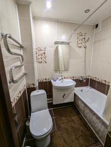 a bathroom with a toilet and a sink and a tub at 1 комнатная квартира in Uralsk