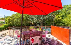 stół i krzesła z czerwonym parasolem na patio w obiekcie Five-Bedroom Holiday Home In Polje w mieście Polje +26 zdjęć