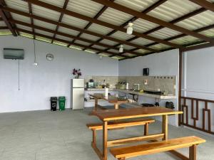 a large room with wooden tables and a kitchen at Encanto Arenal lodge in Fortuna