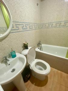 a bathroom with a toilet and a sink and a tub at Great and cozy Room in the center of Puerto del Rosario in Puerto del Rosario