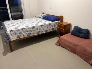 ein Schlafzimmer mit einem Bett und einem Nachttisch sowie einem Bett sidx sidx sidx sidx sidx in der Unterkunft Apto de ferias em Bertioga Maitinga in Bertioga + 35 Fotos