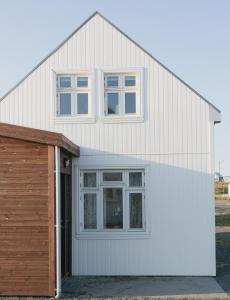 ein großes weißes Haus mit Garage in der Unterkunft Thorshamar sea side villa in Þórshöfn + 36 Fotos