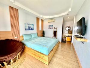a bedroom with a large bed and a flat screen tv at ซันไลท์ เกาะล้าน sun rise kohlarn in Ko Larn