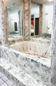 y baño con bañera y 2 espejos. en Western Inn Express, en Hazlehurst 9 fotos más