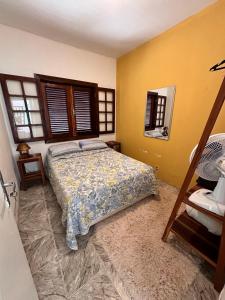 ein Schlafzimmer mit einem Bett und einem Spiegel in der Unterkunft Casa no paraíso Búzios! in Búzios