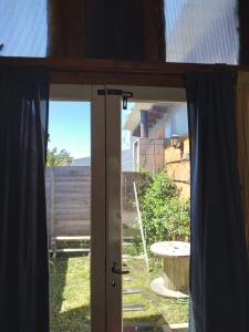 an open glass door with a view of a yard at CasaEstudio 41 esq 24 in Miramar +2 photos