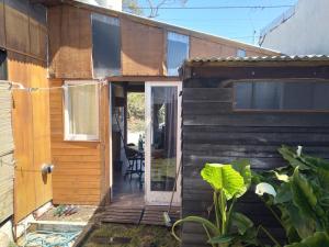 a wooden house with a door and a patio at CasaEstudio 41 esq 24 in Miramar
