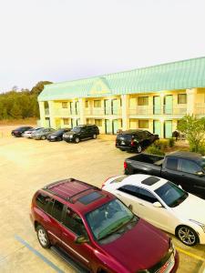 Un estacionamiento con autos estacionados frente a un edificio. en Western Inn Express, en Hazlehurst