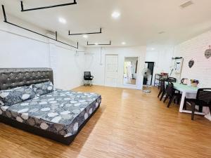 een woonkamer met een bed, een tafel en stoelen bij Eyka Studio Roomstay in Marang