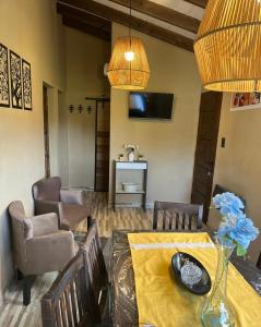 a dining room with a table and chairs and a television at Posada Patagonica in Trevelin
