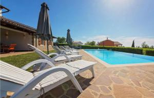 a row of lounge chairs next to a swimming pool at Villa Ciano in Višnjan