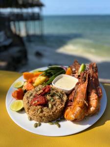 キウェンワにあるZ-Breeze Zanzibarのテーブルの上に置かれたご飯と魚介類の料理