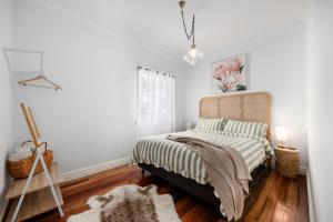 Un dormitorio con una cama con cabecero de madera. en Cottage on Lamington, en Canungra 14 fotos más