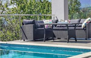 - une table et des chaises à côté de la piscine dans l'établissement Stunning Home In Matulji, à Matulji