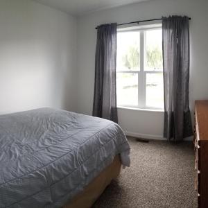 a bedroom with a bed and a window at The Lodge at Lyman's in Houghton Lake