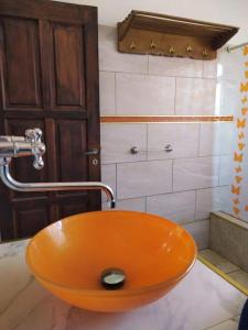 an orange sink in a bathroom with a shower at Casa con piscina, monte y selva en Misiones in Puerto Rico +9 photos