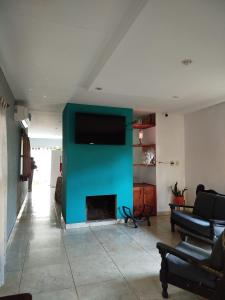 a living room with a fireplace with a flat screen tv at Casa con piscina, monte y selva en Misiones in Puerto Rico