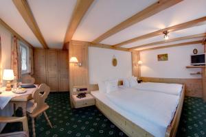 a bedroom with a large bed and a table at Ferienhotel Starennest in Schindelberg