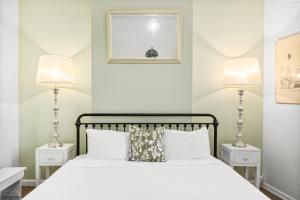 a bedroom with a white bed with two lamps at 'Enmore Lane' A Central Eclectic Artist Escape in Sydney