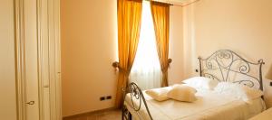 a bedroom with a bed with white pillows and a window at Villa Degli Ulivi in Assisi