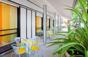a patio with a table and chairs on a balcony at Hotel Universal in Riccione
