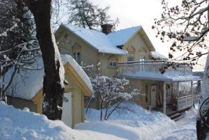 a house is covered in snow with a balcony at Gottfridsgården in Örnsköldsvik