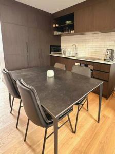 Una mesa de comedor con sillas y una cocina. en Cosy Wanaka Townhouse, en Wanaka 2 fotos más