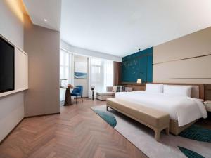 a bedroom with a large bed and a living room at Grand Mercure Hangzhou Qingshan Lake in Hangzhou +132 photos