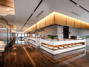 a kitchen with a counter with food on it at Grand Mercure Hangzhou Qingshan Lake in Hangzhou