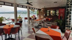 a restaurant with tables and chairs and a view of the water at Hotel Los Angeles in Tequesquitengo