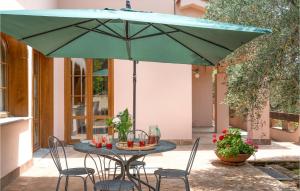 a table with chairs and a green umbrella at Villa Monte Bottigli in Grosseto
