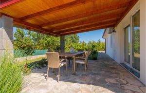 a patio with a wooden pergola and a table and chairs at Three-Bedroom Holiday Home In Vinjani Gornji in Aračići