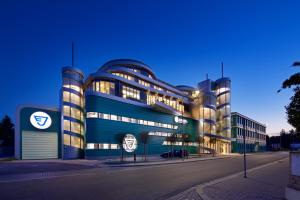 un grand bâtiment bleu avec une voiture garée devant. dans l'établissement Hotel Erwin Junker, à Holice