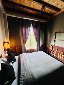 a bedroom with a large bed and a window at Rustique House dbl in Nuwara Eliya