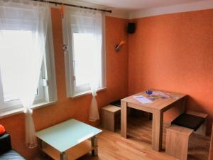 ein kleines Zimmer mit einem Tisch und 2 Fenstern in der Unterkunft Oberhof Apartment in Oberhof