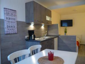 a kitchen with a table with chairs and a sink at Pension Louisa in Dagebüll