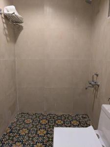 baño con aseo y suelo de baldosa. en Riverside Hobbit House 10mins from Bhimtal, en Bhimtal