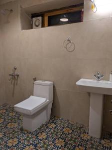 un baño con inodoro y lavabo en Riverside Hobbit House 10mins from Bhimtal, en Bhimtal