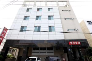 济州市Happy Hotel的一座高楼，前面停着汽车