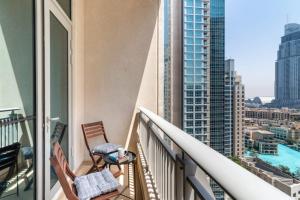 Silkhaus lovely studio with Downtown view in Boulevard central في دبي: بلكونه فيها كرسيين واطلاله على مدينه