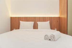 a large white bed with two pillows on it at Good Deal and Cozy 2BR Apartment M-Town Residence near Mall By Travelio in Tangerang