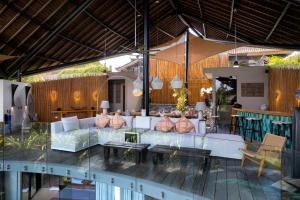 a lobby with a couch and tables and chairs at Villa Toraja in Canggu