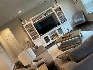 a living room with a couch and a flat screen tv at Toscana Villa in Round Rock