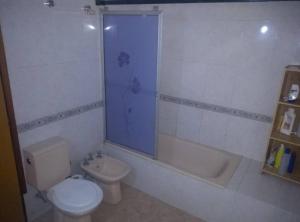 a bathroom with a toilet and a tub and a sink at La casa de la ti in Lanús +1 photo