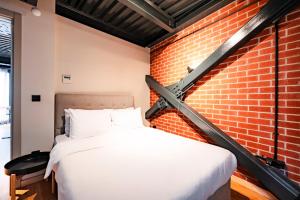 Bett in einem Zimmer mit Ziegelwand in der Unterkunft Homie Suites - ''Loft 27'' Urban Comfort Suites in the Heart of Cihangir in Istanbul