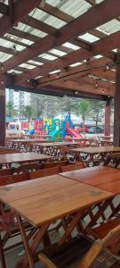 a classroom with wooden tables and a train in the background at Sua casa longe de casa in Mongaguá